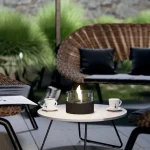 Tenderflame Cafe 18 MGO black on a coffee table with wicker furniture