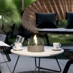 Tenderflame Cafe 18 MGO concrete on a coffee table with wicker furniture