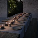 Long Table in the garden at night with lots of Breeze 10 Tenderflame candles