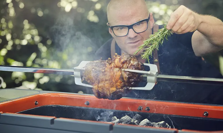 Heston Blumenthal cooking on a Everdure Hub charcoal bbq in the garden